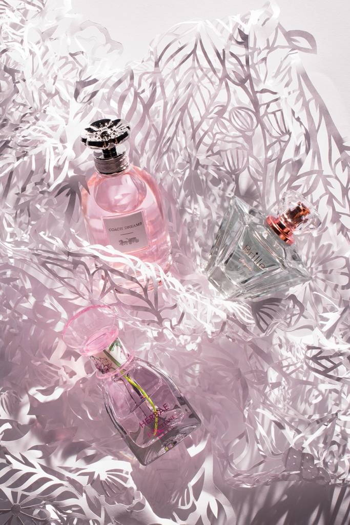 Imagem de três perfumes. Da esquerda para a direita: Herbae Par L’Occitane L’Eau da L’Occitane en Provence, Coach Dreams da Coach e Brille da Jequiti.