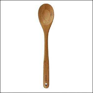 A imagem mostra uma colher de bamboo na cor marrom, em pé em um fundo branco