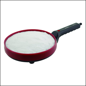 Crepeira-3-em-1-Britânia A imagem mostra uma crepeira redonda, do formato de uma frigideira, na cor vermelha e com o cabo preto. É possível ver uma farinha de tapioca cobrindo a superfície da panela. O fundo da imagem é branco.