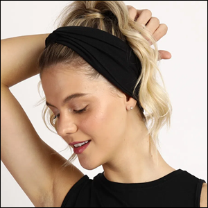Faixa-de-Cabelo-Entrelaçada-Preta Imagem de uma mulher caucasiana de cabelos loiros com a face virada para seu lado direito e olhando para baixo. Em sua cabeça encontra-se uma faixa de cabelo preta.