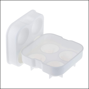 Forma-De-Gelo-Esferas-Em-Silicone-Com-Tampa-Weck A imagem mostra uma forma de gelo de formato quadrado com 4 espaços redondos para fazer o gelo. Em pé, ao lado da base, há a tampa da forma. O fundo da imagem é branco.