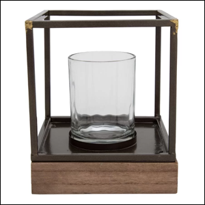 Imagem de uma lanterna de mesa no formato quadrado, com suporte para vela pequena. Sua base é em madeira, onde há um compartimento semelhante a um pequeno copo de vidro envolto por uma moldura de metal preto. e