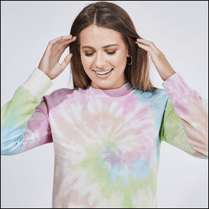 Moletom-Tie-Dye-YOUCOM Imagem de menina caucasiana de cabelos castanhos vestindo um moletom com estampa tie dye nas cores pasteis rosa, azul verde e branco.
