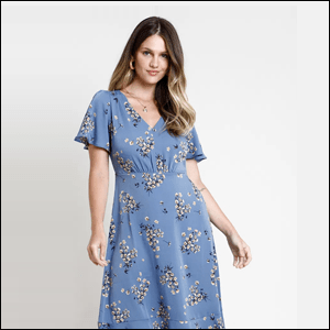 Vestido-Midi-Estampado-Floral-Yessica Imagem de uma mulher caucasiana e cabelos castanhos com um vestido azul estampado de flores.