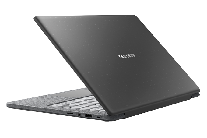 A imagem mostra um notebook cinza escuro, entreaberto, virado de costas,com teclas cinza claro, num fundo branco.