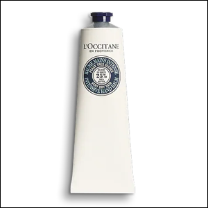 Creme-de-Mãos-Nutrição-Karité-L’Occitane A imagem mostra a embalagem do creme de mão Nutrição, na cor branca com tampa azul escuro, em formato de bisnaga. No centro da embalagem, é possível ver um círculo azul marinho contendo as informações sobre o produto e, em cima dele, o nome da marca também na cor azul. O fundo da imagem é branco.