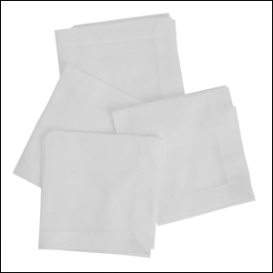 A imagem mostra um conjunto de 4 guardanapos de tecido, na cor branca, com um detalhe bordado na borda. O fundo da imagem é branco.