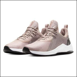A imagem mostra um par de tênis da Nike, no modelo Air Max Bella TR 3 feminino, na cor rosa, com a parte da sola branca e alguns detalhes em prata. O fundo da imagem é branco.