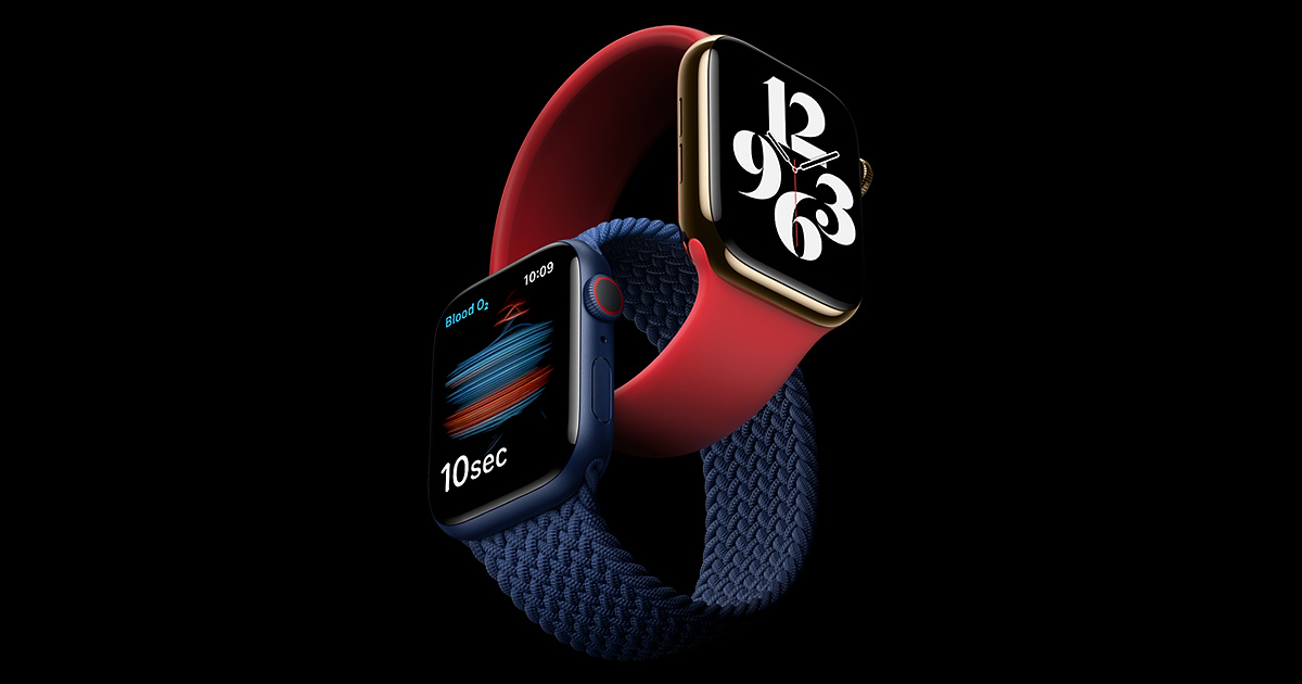 A imagem mostra dois Apple Watch entrelaçados, um com a pulseira vermelha de silicone e outro com a pulseira azul marinho trançada. Ambos possuem um visor digital na formato quadrado. O relógio com a pulseira vermelha mostra um visor de relógio, com os números 3, 6, 9 e 12 na cor branca, enquanto o com pulseira azul mostra os batimentos por segundo. O fundo da imagem é preto.