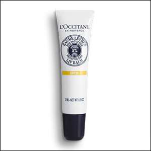 Bálsamo-labial-Karité-FPS-30-L’Occitane A imagem mostra a embalagem do produto, uma bisnaga na cor branca com tampa azul escura. As informações do produto aparecem em letras na cor azul escuro.