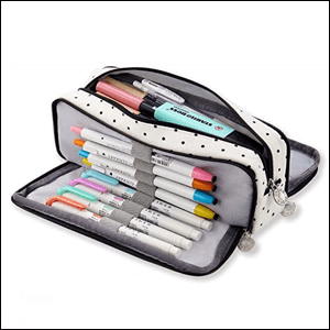 A imagem mostra um estojo aberto, tanto na parte de cima, quanto dos lados, na cor branca com bolinhas pretas. Dentro dele é possível ver uma série de canetas coloridas.