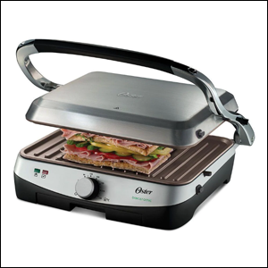 A imagem mostra um grill quadrado, na cor prata. Ele está semi aberto, mostrando um sanduíche sendo tostado em seu interior.