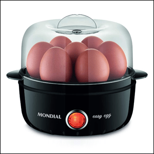 A imagem mostra um cozinhador de ovos, no formato de uma pequena panela, com a base na cor preta e uma luz laranja e redonda na frente, com uma tampa transparente, que permite ver os ovos cozinhando dentro do recipiente.