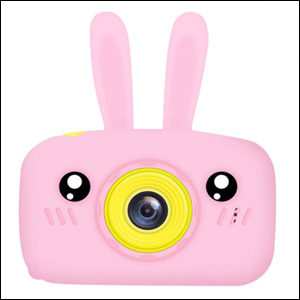 A imagem mostra uma câmera digital retangular da cor rosa, com o entorno da lente na cor amarelo. A câmera possui duas orelhas de coelho também na cor rosa, além de ter um círculo preto em cada lado da lente, formando uma carinha no brinquedo.