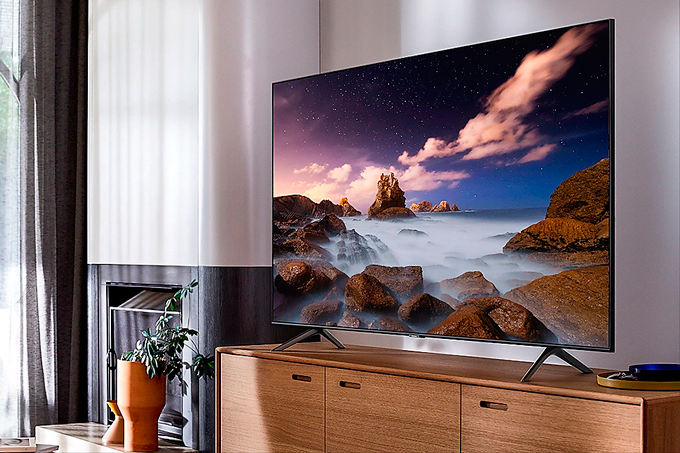 A imagem mostra uma Smart TV Q60T sobre um móvel de madeira.