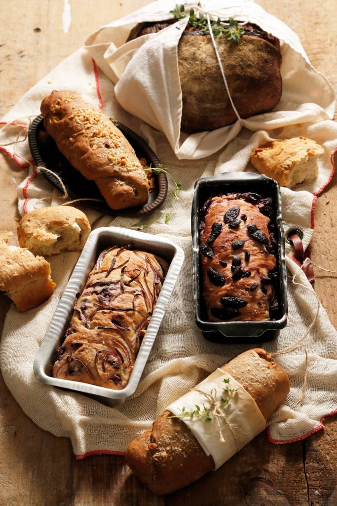 A imagem mostra uma mesa com diversos pães.