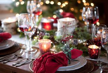 Mesa de Natal com velas, guardanapo vermelho e taças de vinho