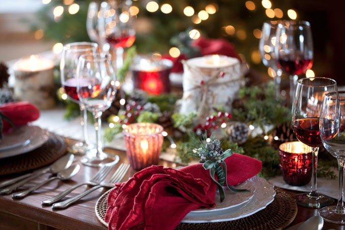 Mesa de Natal com velas, guardanapo vermelho e taças de vinho
