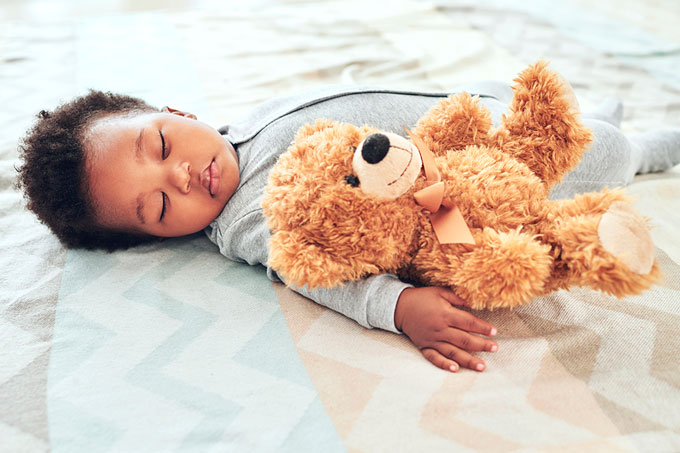 Bebê dormindo com urso de pelúcia