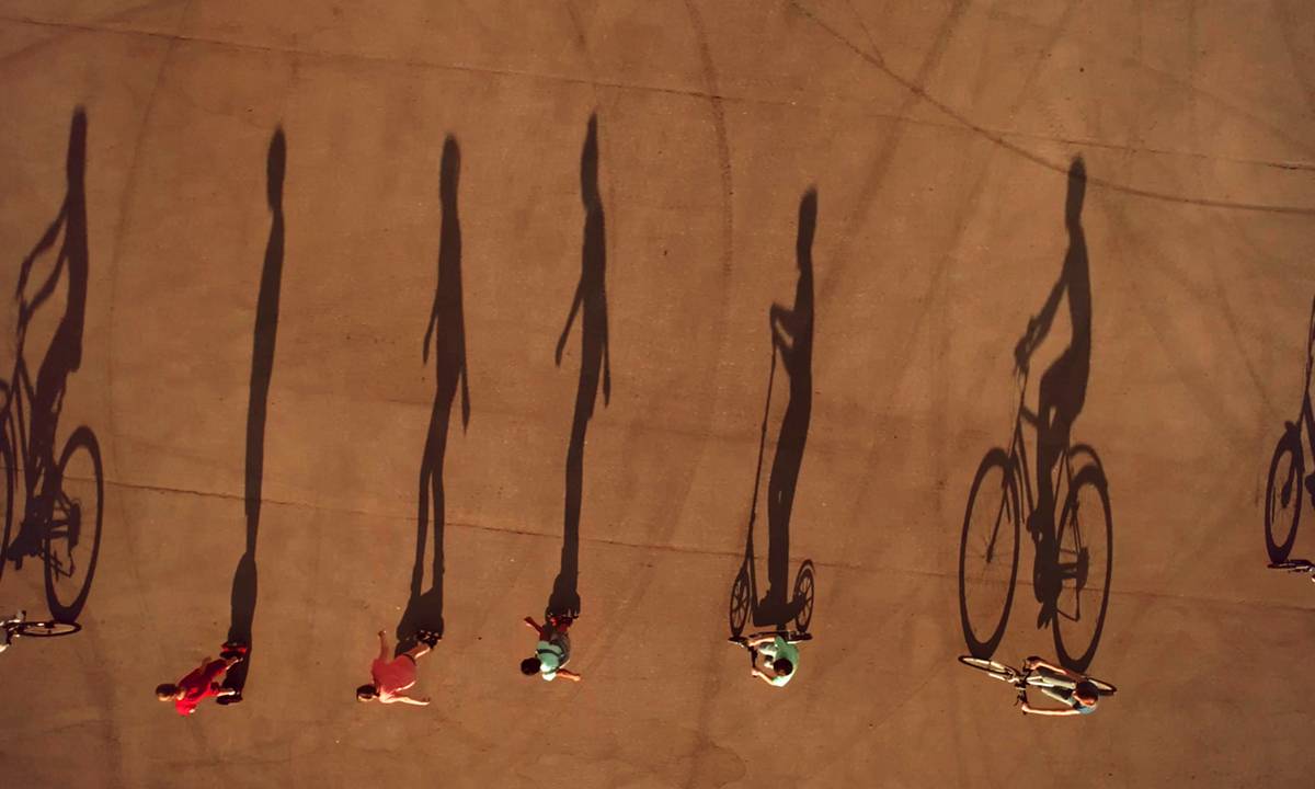 sombra projetada de pessoas andando de patinete, hoaverboard e bicicleta