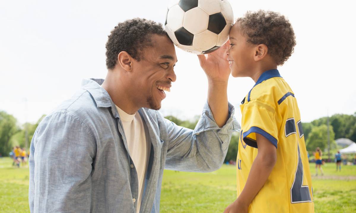 Pai e filho com bola de futebol