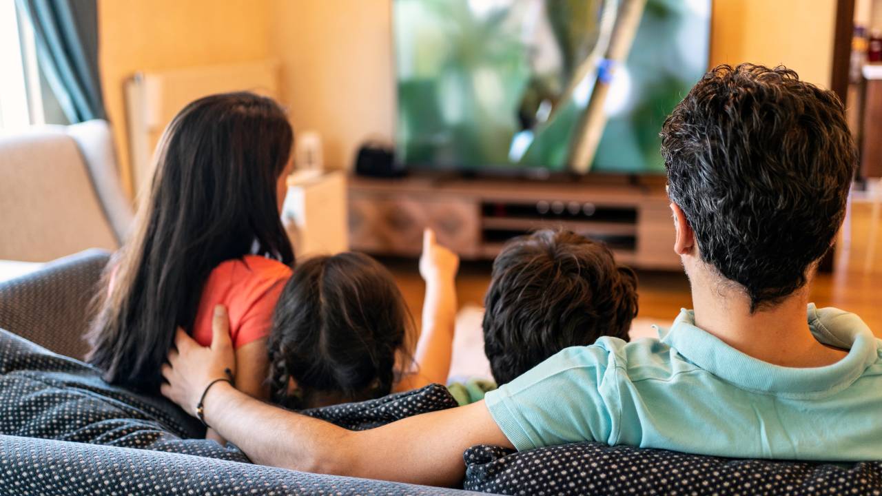 foto de família assistindo televisão na sala de casa