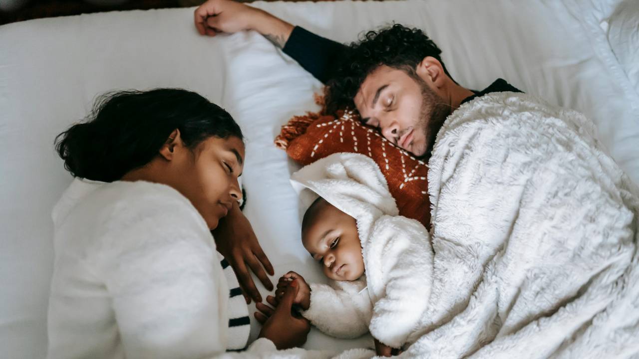 mãe, pai e bebê dormindo juntos