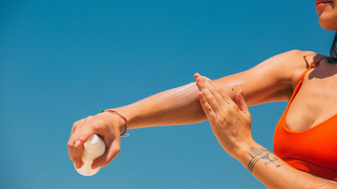 protetor solar mulher passando praia verão