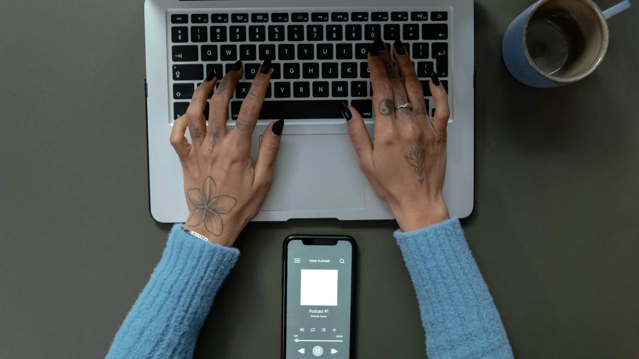 pessoa digitando no computador e ouvindo podcast