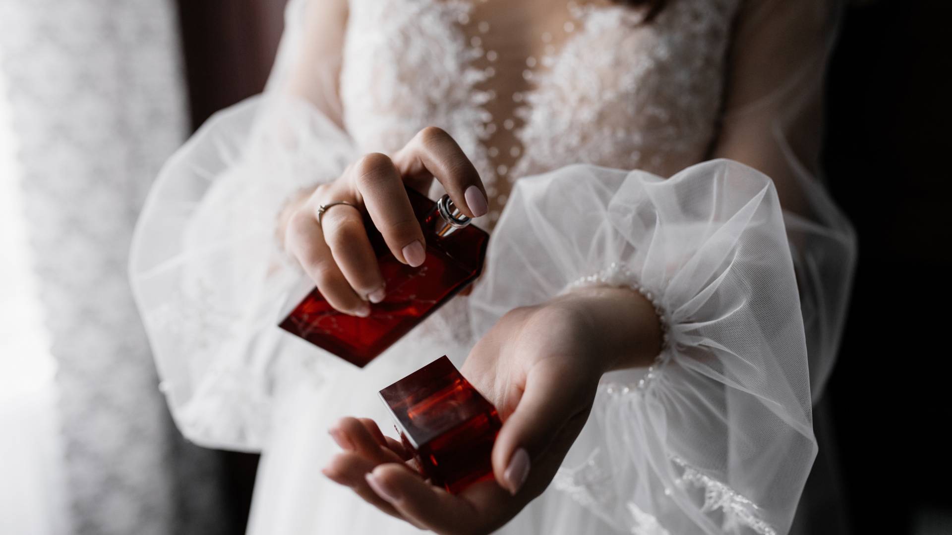 Fiancee in white fashionable dress with beautiful sleeves and pe perfumes